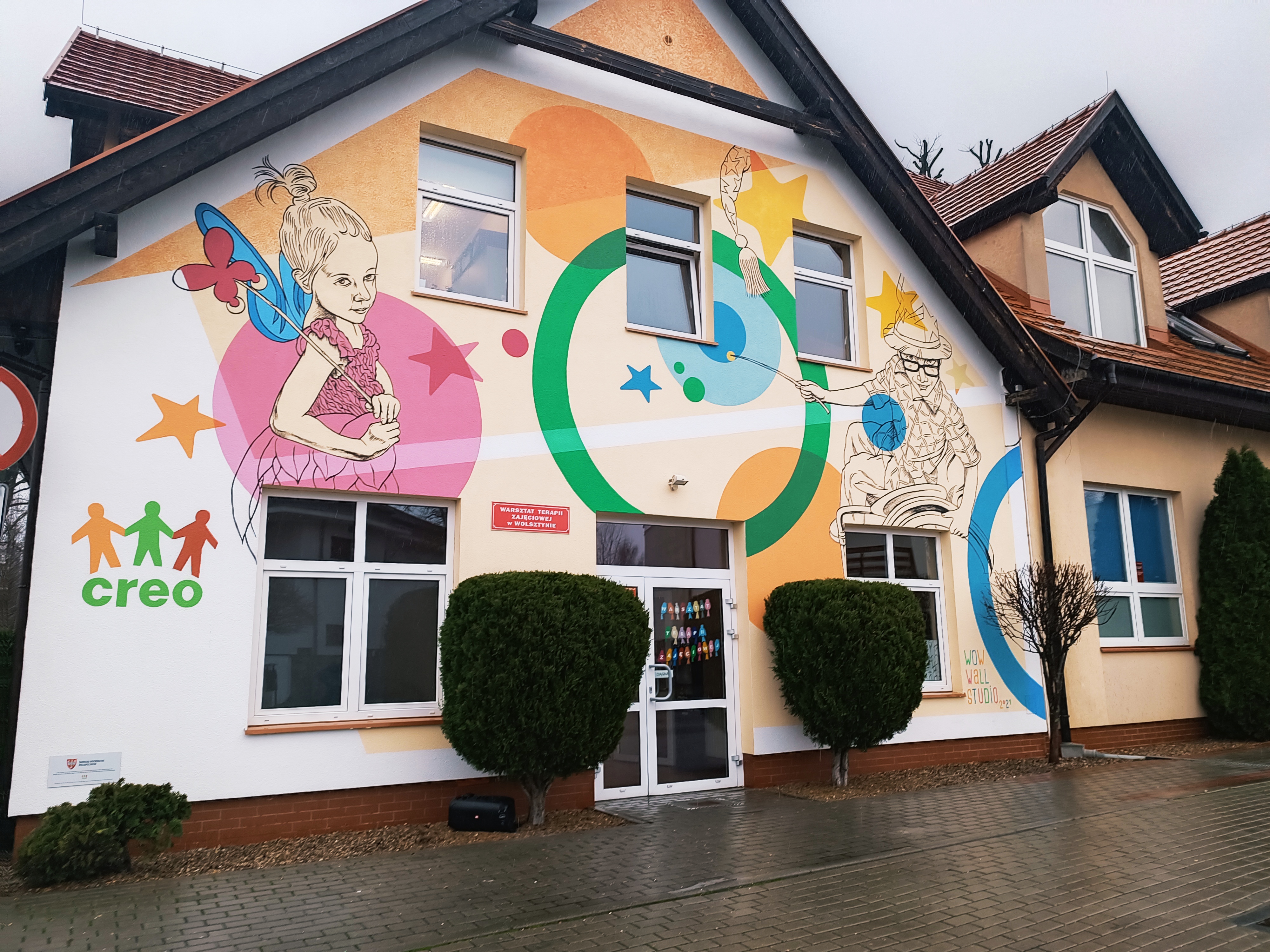 Kolorowy i wesoły mural na budynku prezentujący dzieciaki z niepełnnosprawnościami.