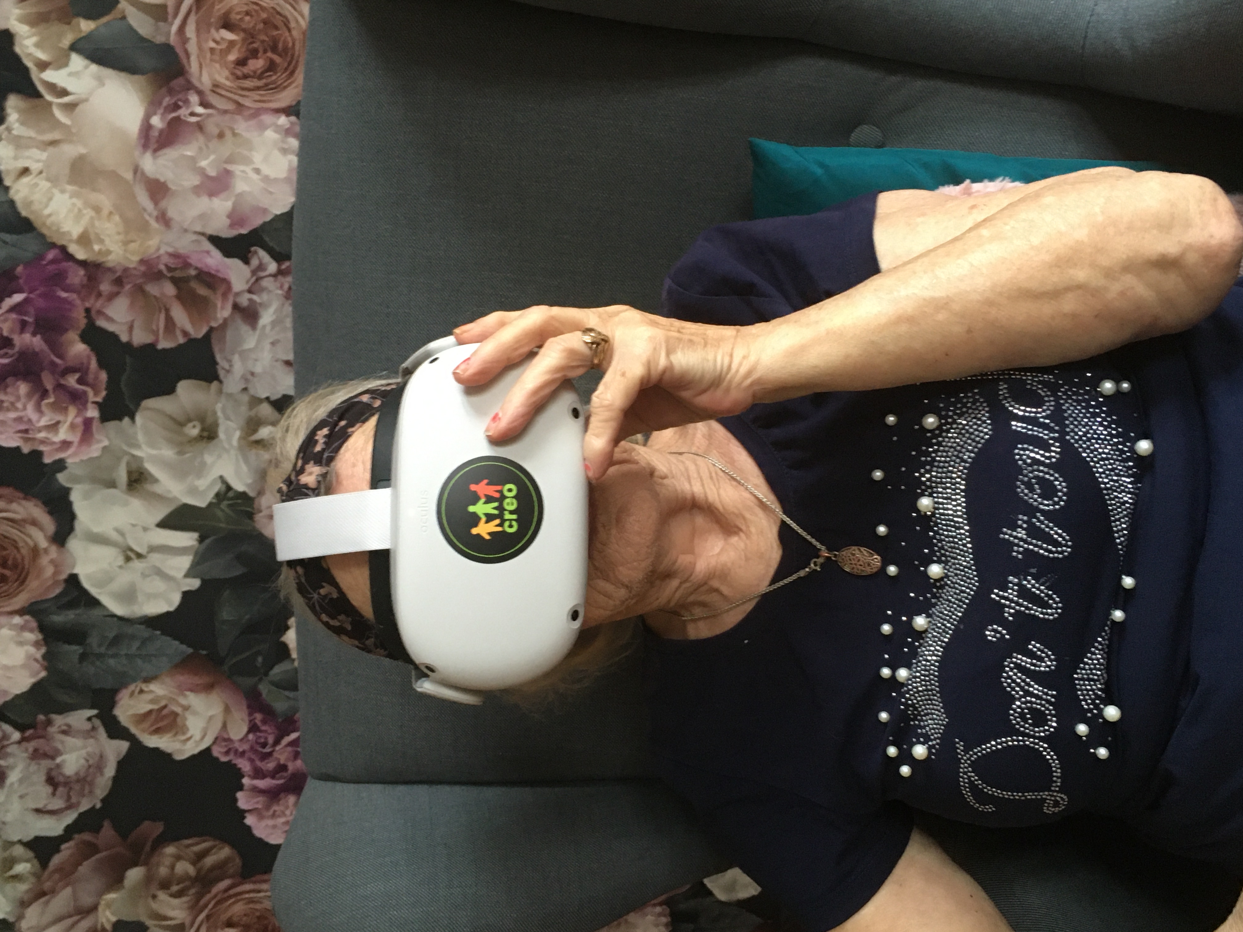 Seniorka w okularach VR skupiona śledzi wirtualną rzeczywistość.